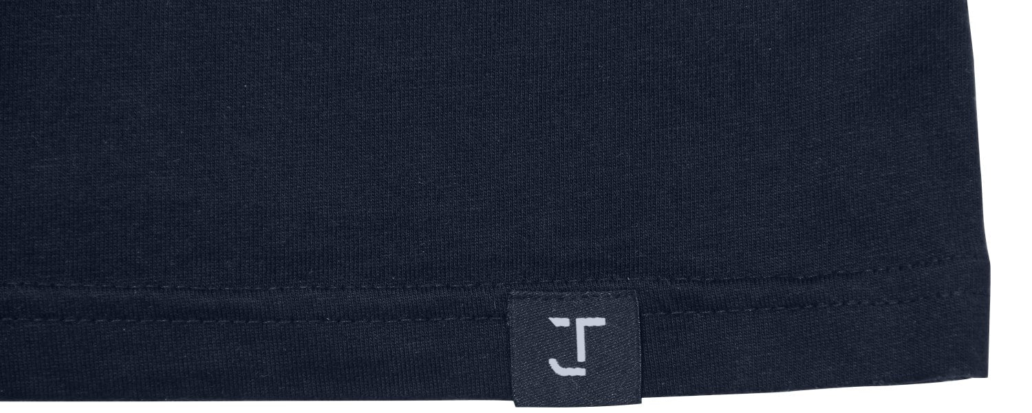 A close up of the Just Tall monogram logo on the bottom t-shirt hem.