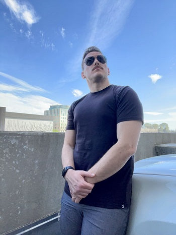 A tall muscular guy wearing a black XL tall t-shirt.