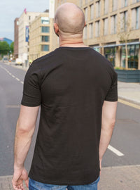 Thumbnail for A shot from behind of a tall skinny guy wearing a tall slim graphic t-shirt.