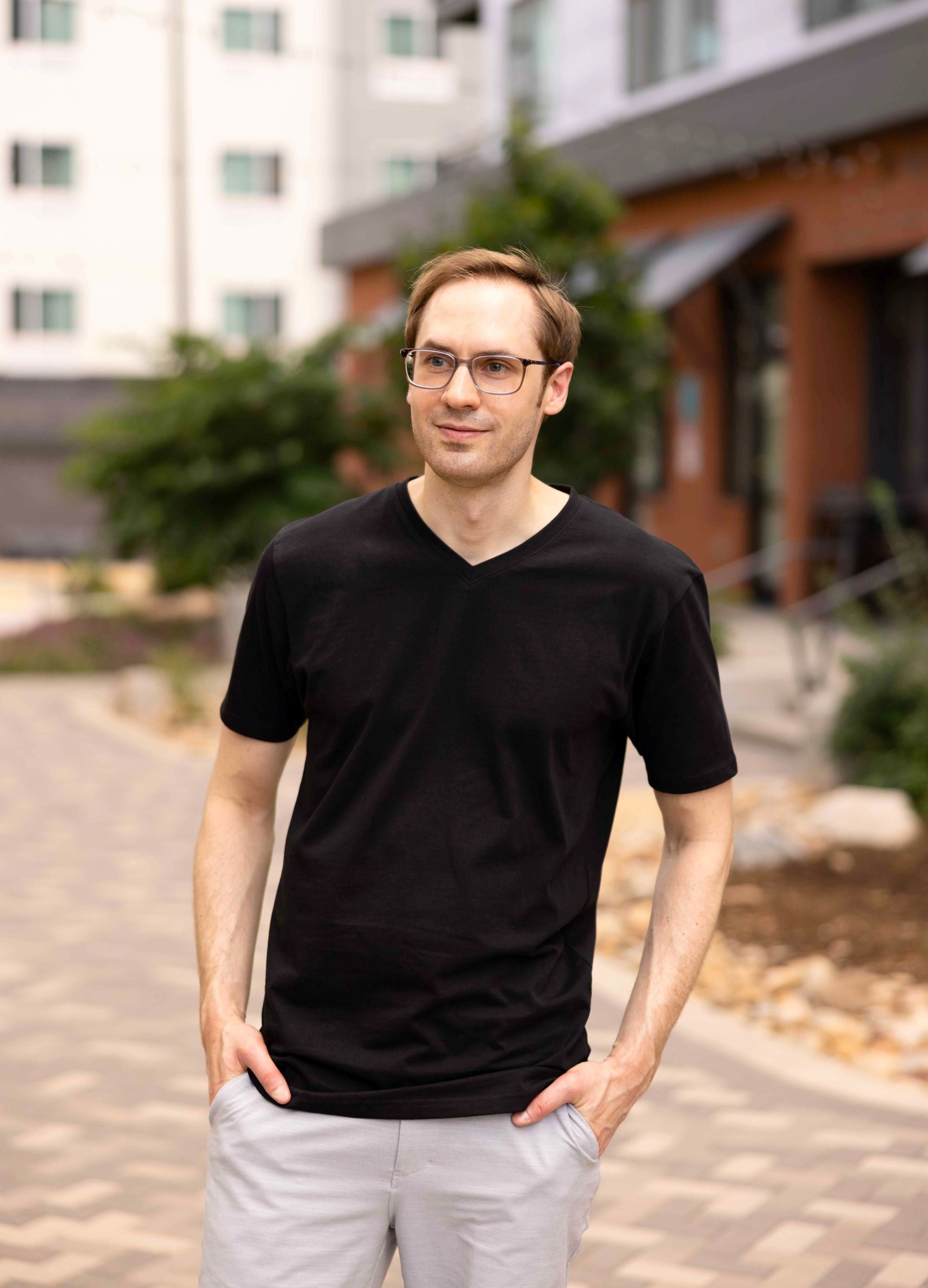 A tall slim guy wearing a large tall black v-neck t-shirt.