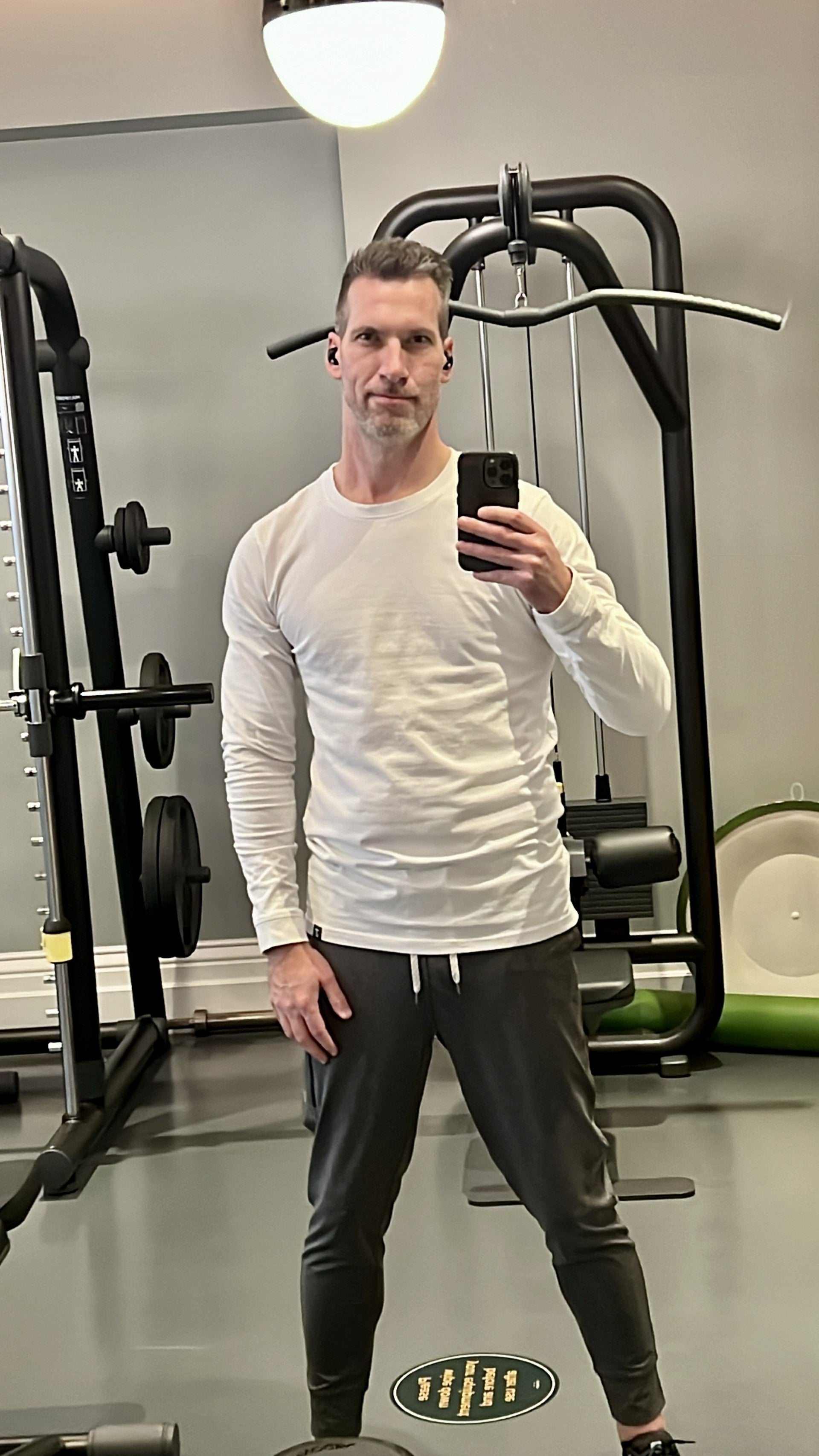 A tall slim guy wearing a medium tall white long sleeve t-shirt.