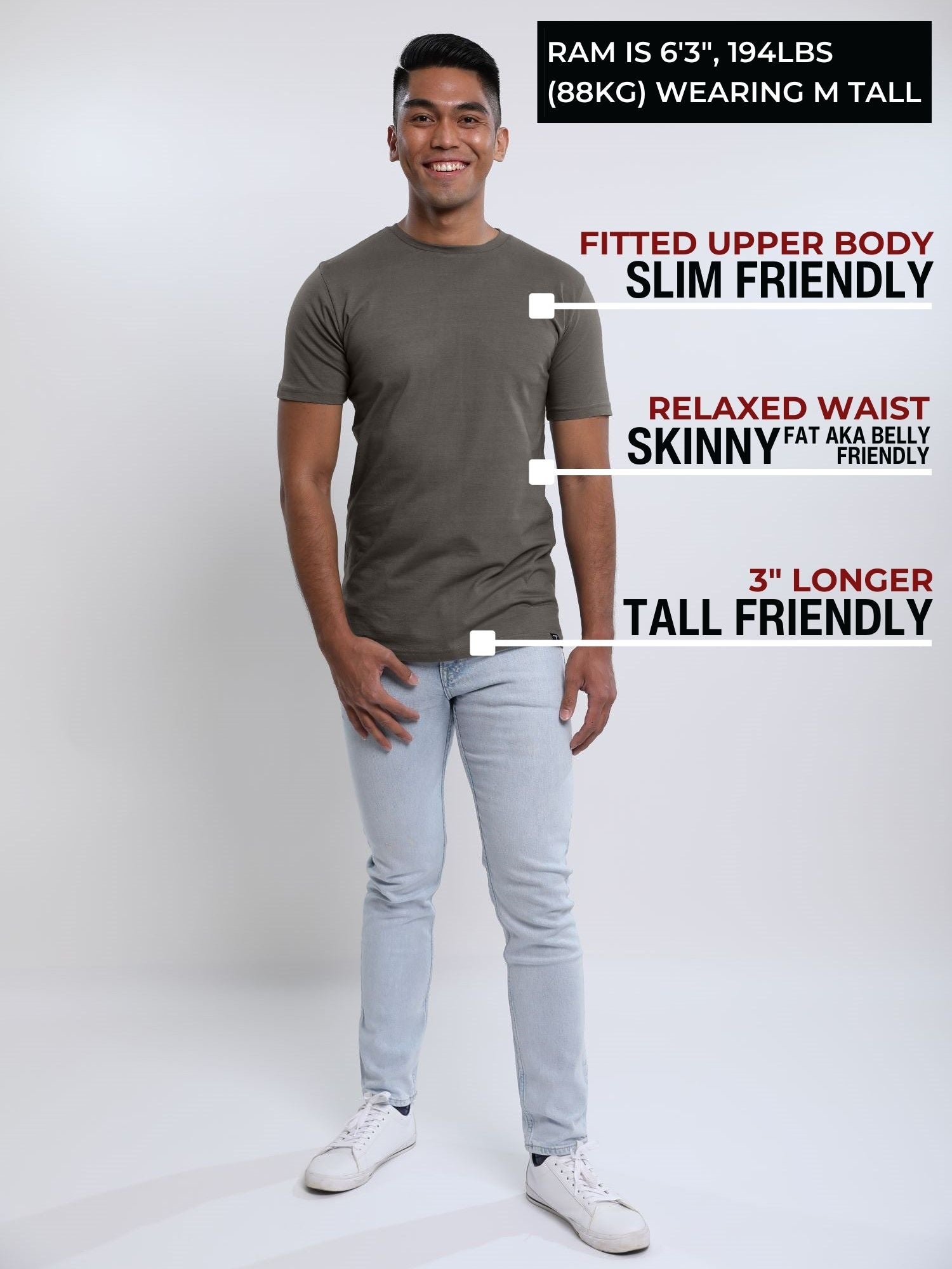 A head to toe shot of a tall slim guy in a studio and wearing a dark grey medium tall slim t-shirt.