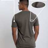 A shot from behind of a tall and slim guy in a studio and wearing a dark grey medium tall slim t-shirt.