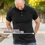 An upper body shot of a tall athletic guy in a park and wearing an XL tall slim black polo shirt and showing the minimal Just Tall flag logo near the bottom of the side seam.