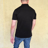 A shot from behind of a tall slim man wearing an XL tall zip polo shirt.