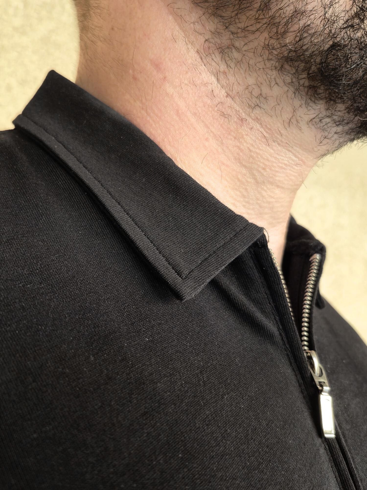 A close up Just Tall's stay-flat collar on their tall zip polo shirt.