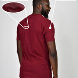 A shot from behind of a tall and slim guy in a studio and wearing a cabernet large tall slim t-shirt.