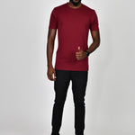 A head to toe shot of a tall slim guy in a studio and wearing a cabernet large tall slim t-shirt.