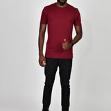 A head to toe shot of a tall slim guy in a studio and wearing a cabernet large tall slim t-shirt.