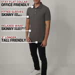 A head to toe shot of a tall slim man in a studio wearing a dark grey medium tall polo shirt.