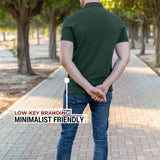 A shot from behind of a tall athletic guy in a park and wearing an XL tall slim dark pine polo shirt and showing the minimal Just Tall flag logo near the bottom of the side seam.