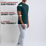 A head to toe shot of a tall slim guy in a studio and wearing a dark teal medium tall slim t-shirt.