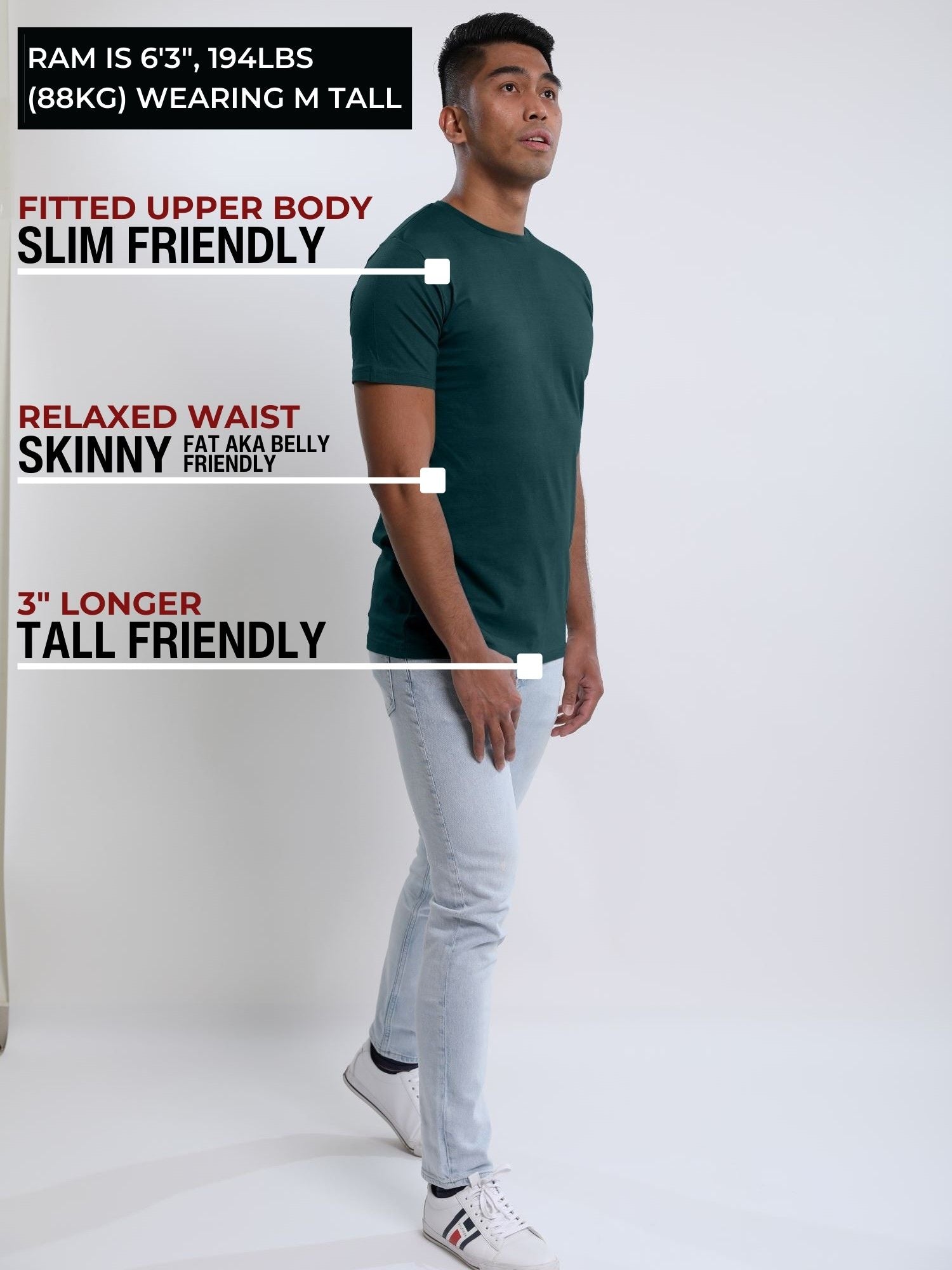 A head to toe shot of a tall slim guy in a studio and wearing a dark teal medium tall slim t-shirt.