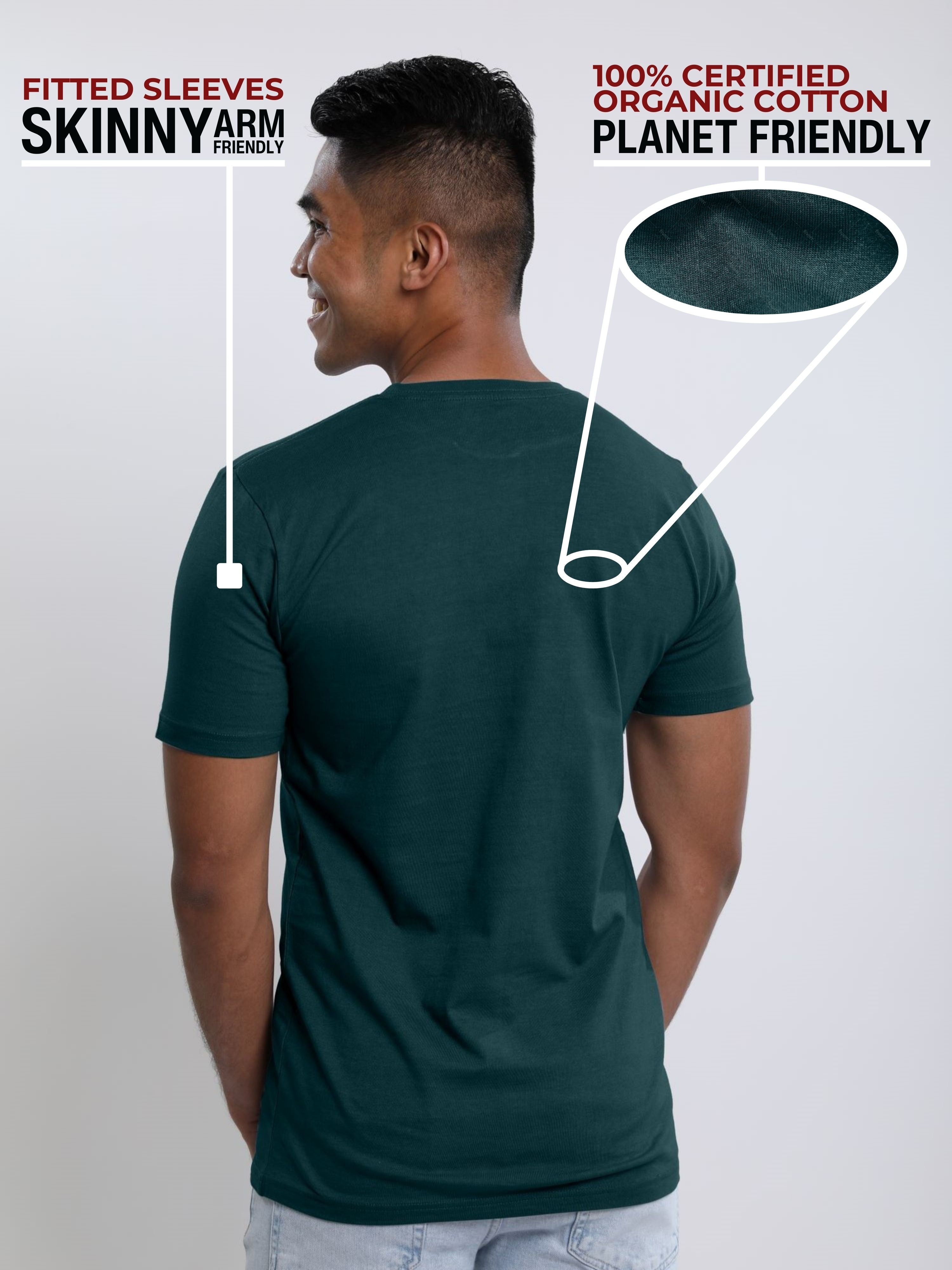 A shot from behind of a tall and slim guy in a studio and wearing a dark teal medium tall slim t-shirt.