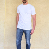 A head to toe shot of a tall slim guy wearing an XL tall white heavyweight t-shirt.