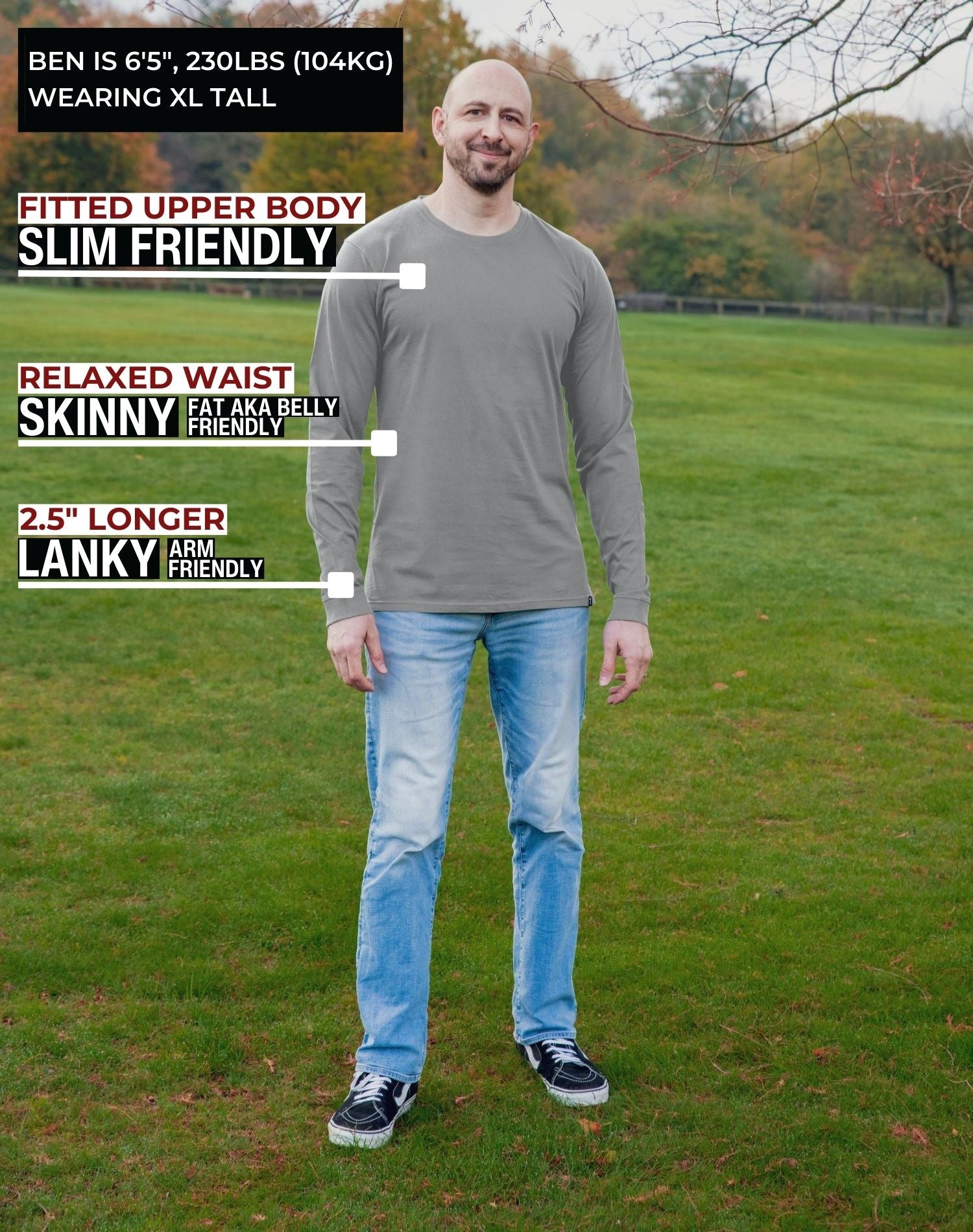 A head to toe shot of a tall athletic guy in a park wearing a light grey long sleeve tall t-shirt.