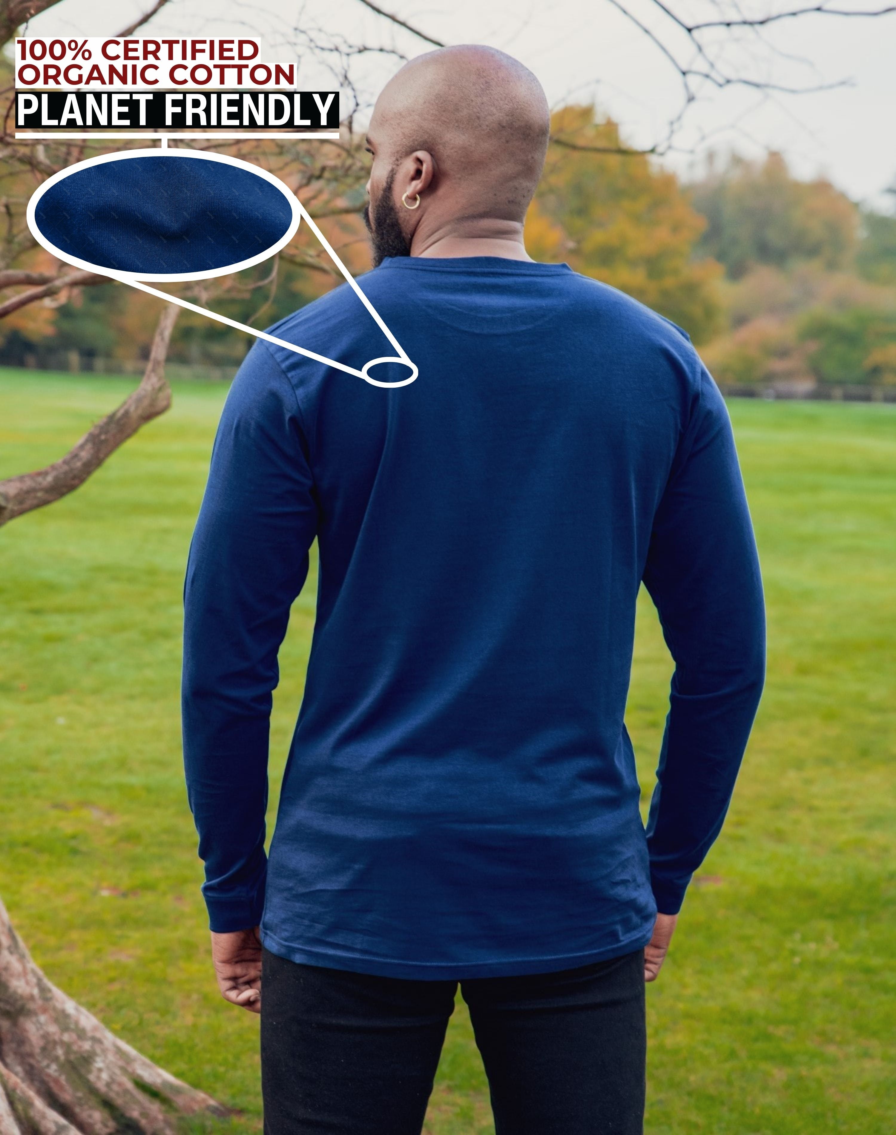 A shot from behind of a tall slim guy in a park wearing an extra long sleeve long sleeve tall t-shirt in navy.
