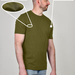 A side shot of a tall and slim guy in a studio and wearing an olive XL tall slim t-shirt.
