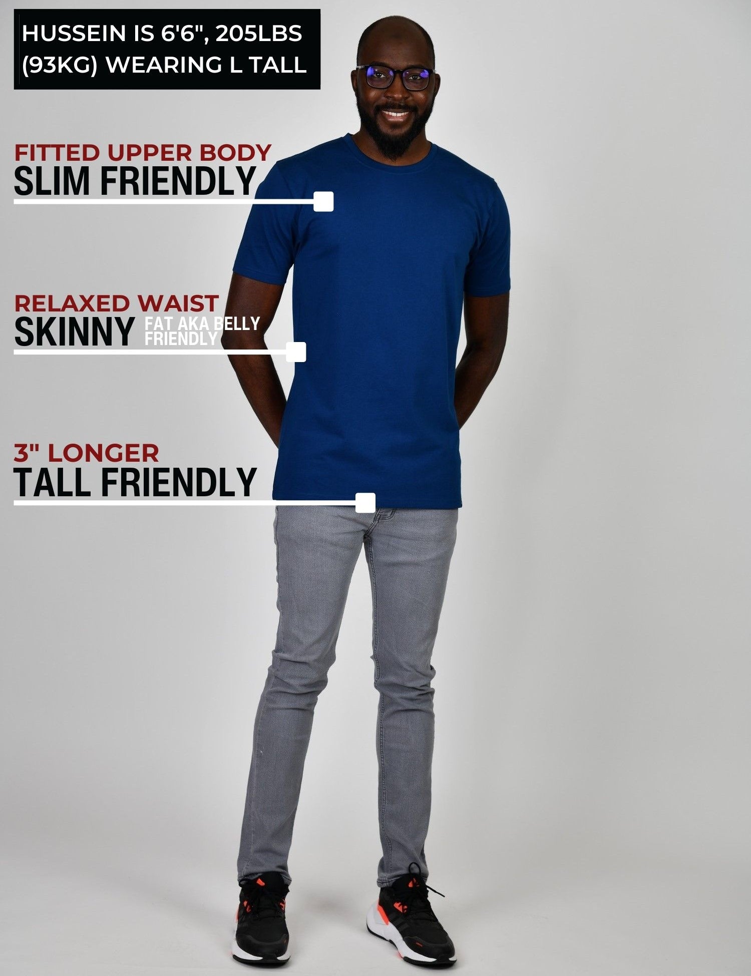 A head to toe shot of a tall slim guy in a studio and wearing a navy large tall slim t-shirt.