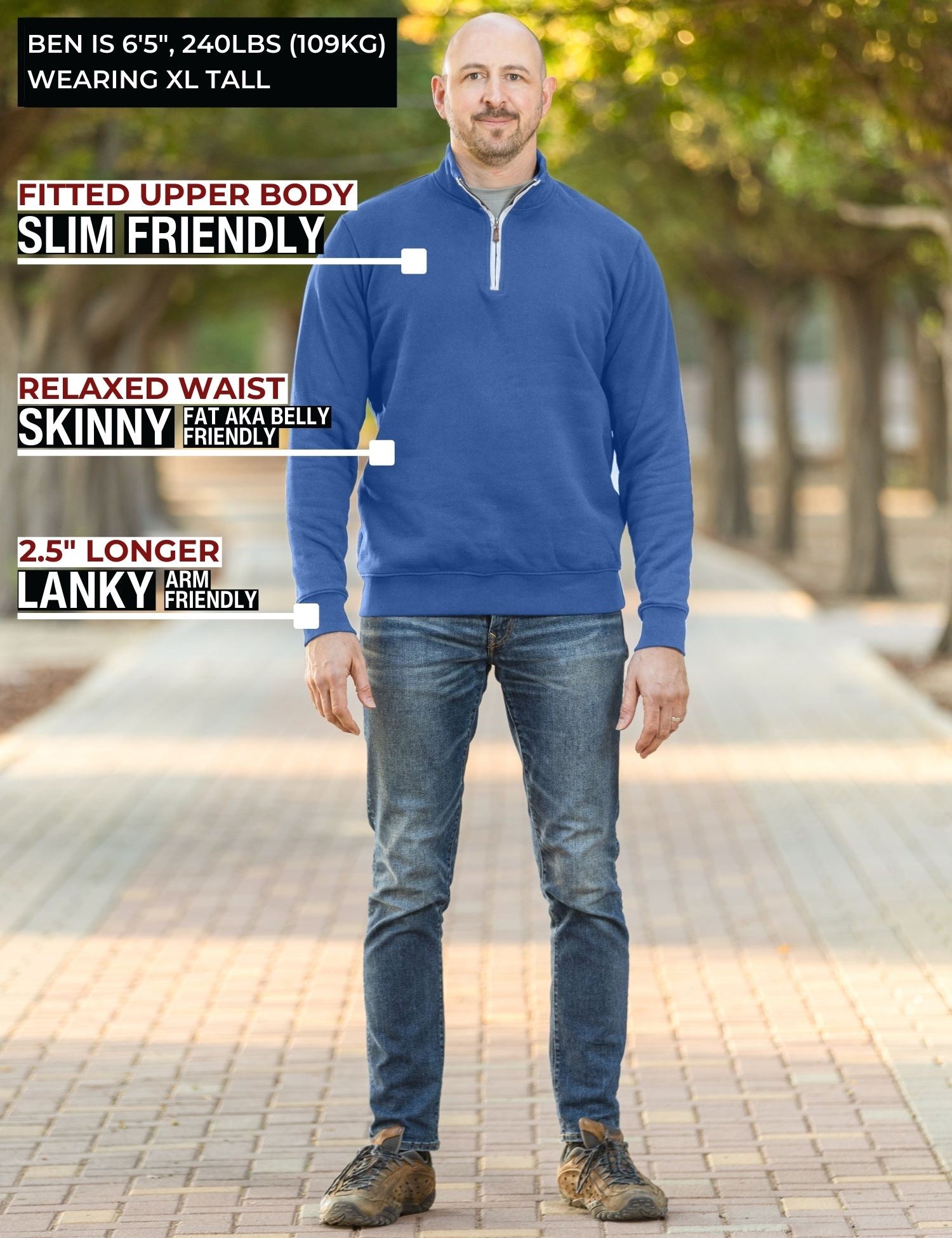 A head to toe shot of a tall athletic guy in a park wearing an XL tall extra long cobalt quarter zip sweatshirt.