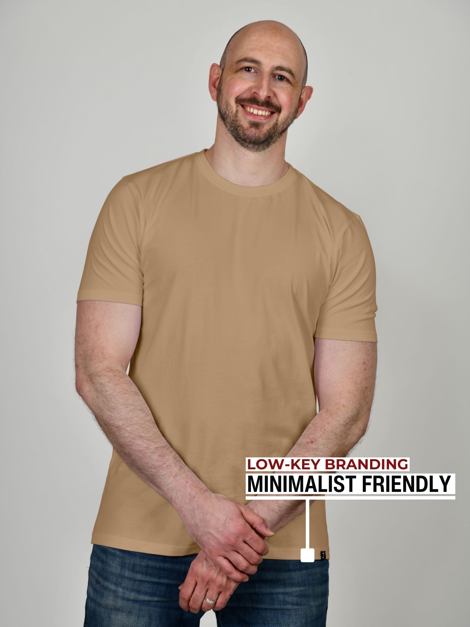 An upper body shot of a tall athletic guy in a studio and wearing a tan extra large tall slim t-shirt.