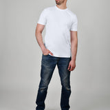 A head to toe shot of a tall and slim guy in the studio wearing a white XL tall slim t-shirt.