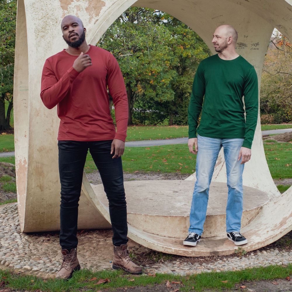 Two tall lean guys wearing long sleeve plain tall t-shirts in green and dark orange.