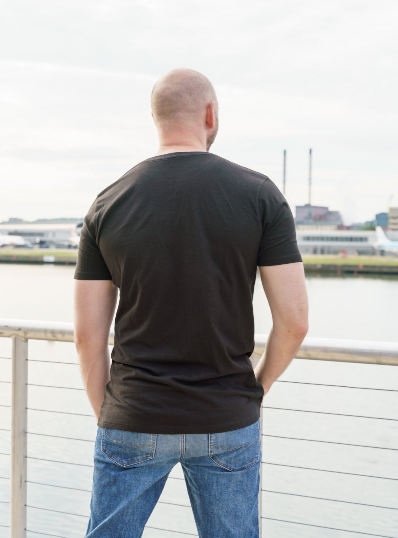 A shot from behind of a tall skinny guy wearing a tall black t-shirt