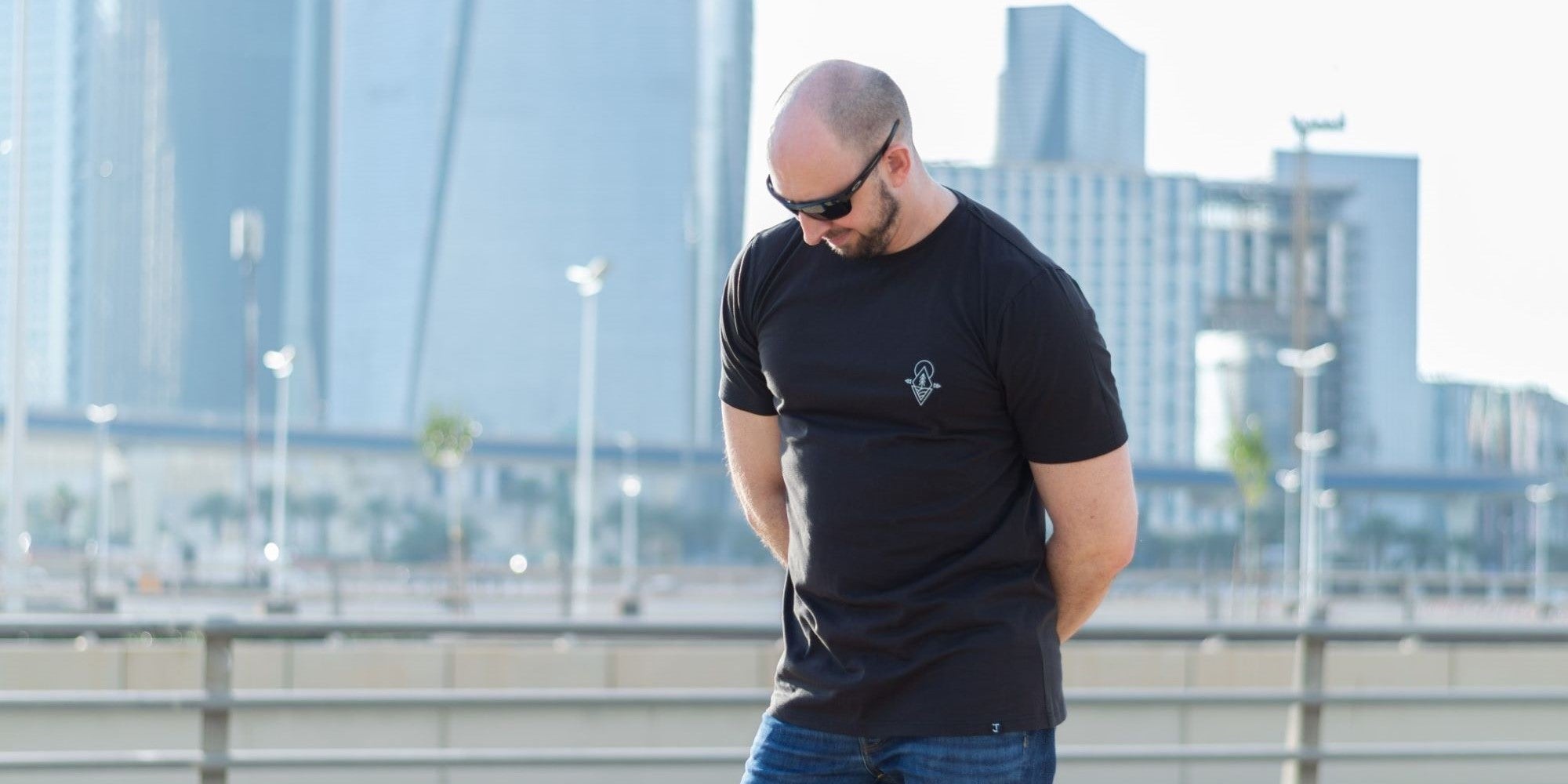 A tall skinny guy wearing a black graphic tall t-shirt.