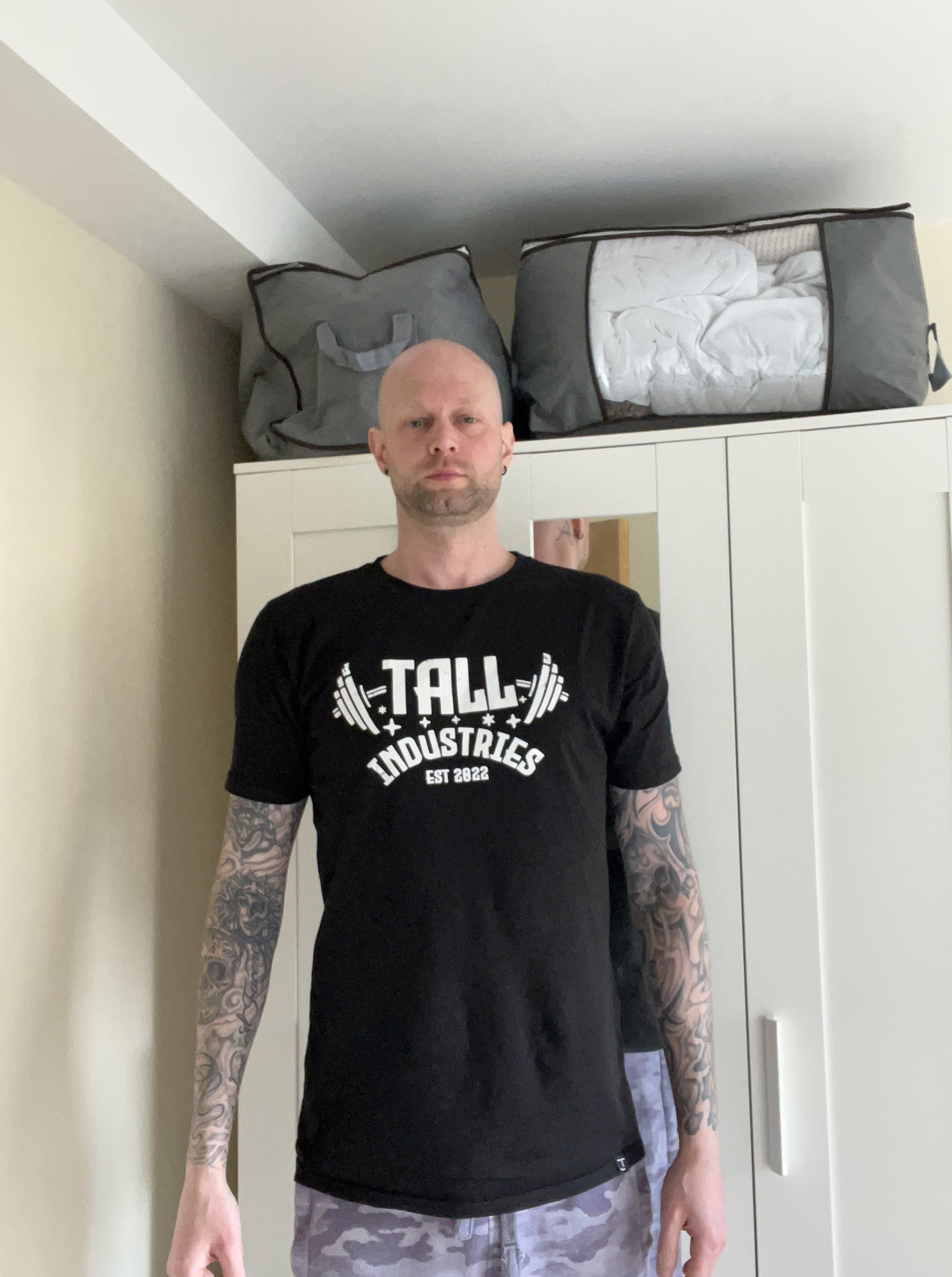 A tall athletic guy wearing a large tall graphic t-shirt.