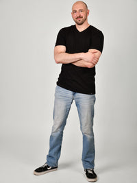 Thumbnail for A head to toe shot of a tall and slim guy in the studio wearing a black XL tall slim v-neck t-shirt.