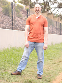 Thumbnail for A tall skinny guy wearing a tall brown henley shirt and smiling.