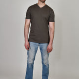 A head to toe shot of a tall and slim guy in the studio wearing a dark grey XL tall slim v-neck t-shirt.