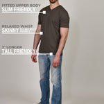 A head to toe shot of a tall and slim guy in the studio wearing a dark grey XL tall slim v-neck t-shirt.