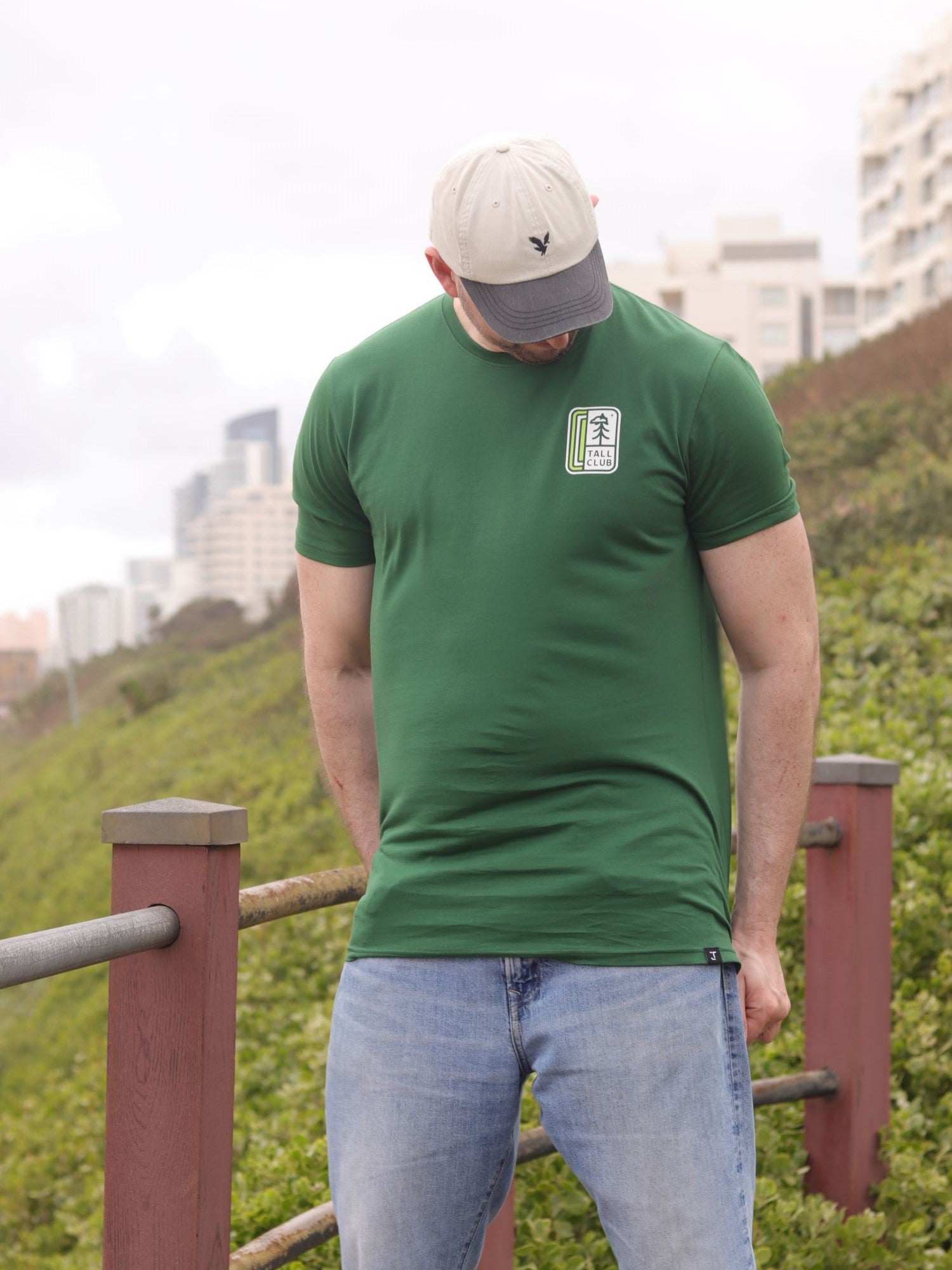 An upper body shot of a tall slim guy in an XL tall graphic t-shirt with a tall club design.