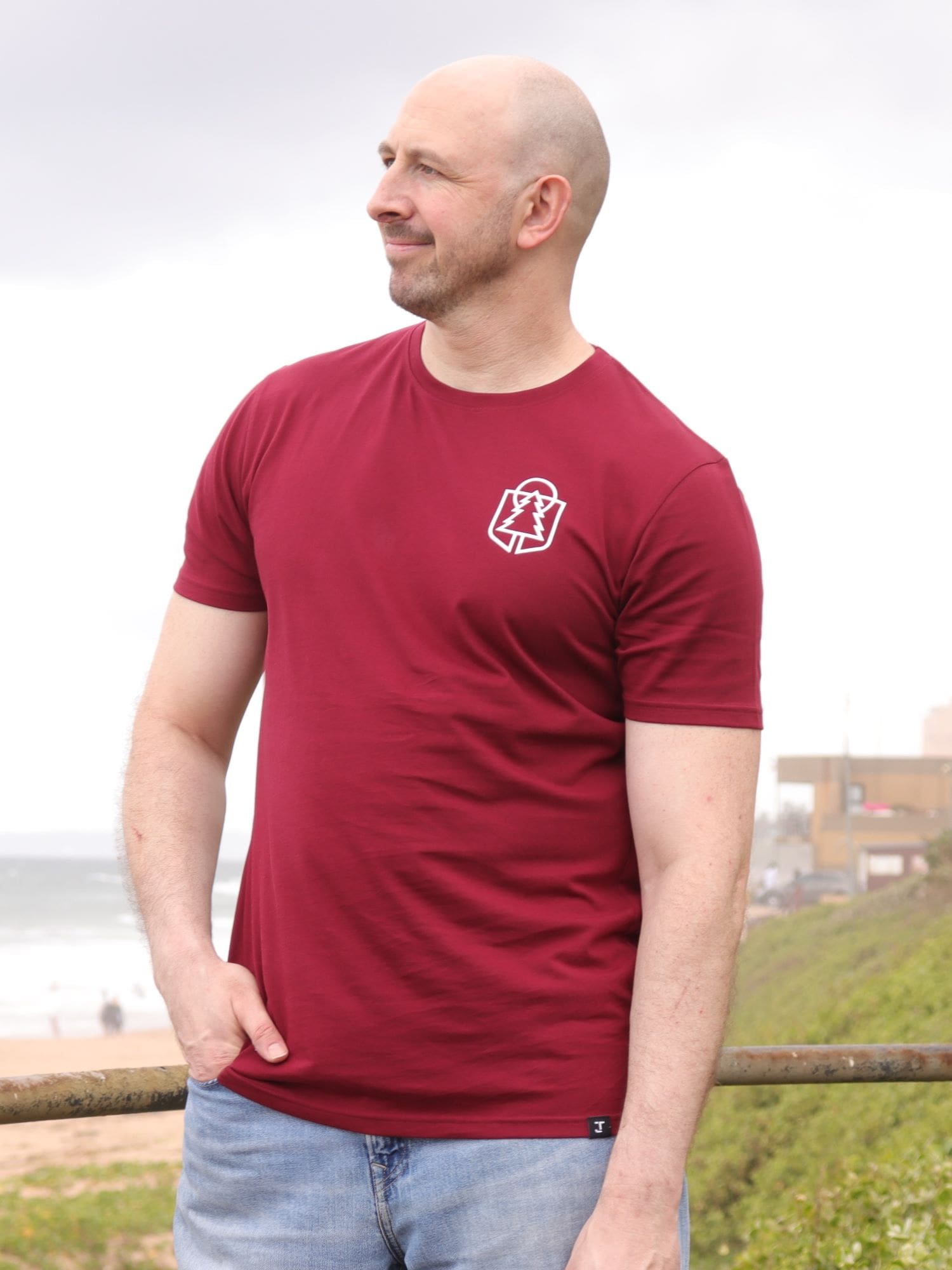 A tall slim guy wearing an XL tall graphic t-shirt with a tree design, looking to the left.