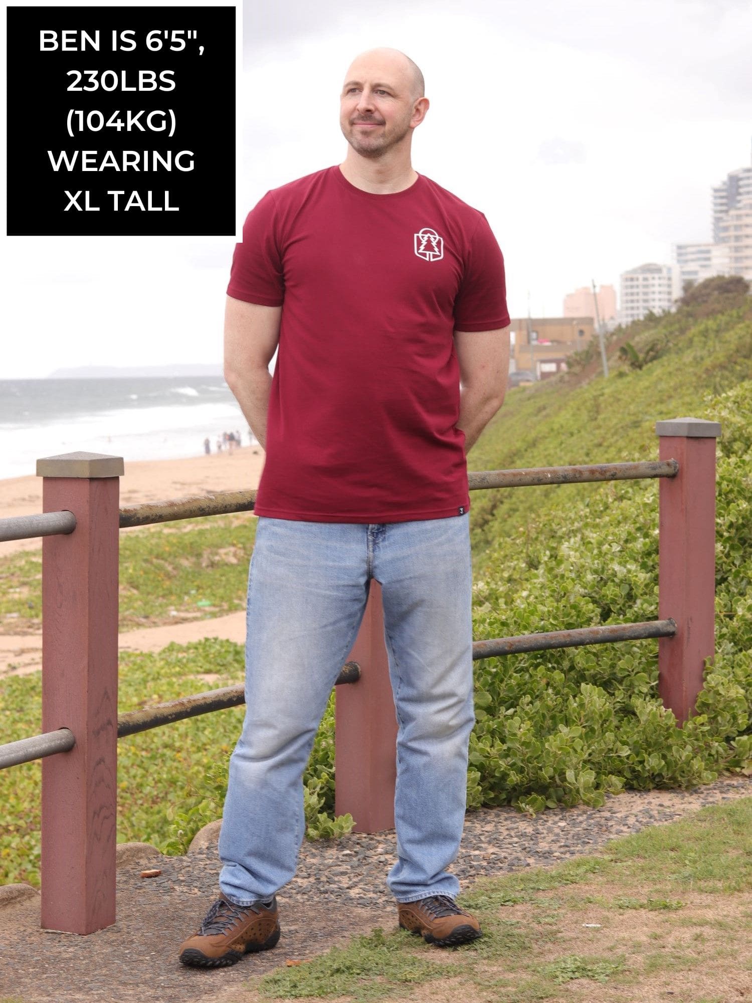 A head to toe shot of a tall skinny guy wearing an XL tall graphic t-shirt with a tree design.
