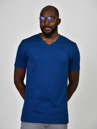 Thumbnail for A tall and slim guy in the studio, hands behind back and wearing a navy blue L tall slim v-neck t-shirt.