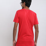 A shot from behind of a tall skinny guy in the studio wearing a red small tall slim t-shirt.