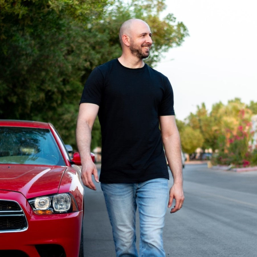 A tall skinny guy wearing a black XL tall slim t-shirt.