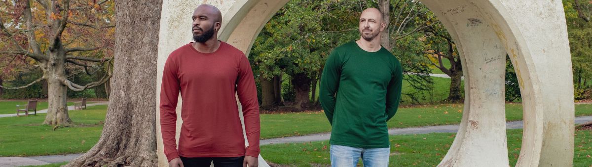 Two tall athletic guys wearing orange and green extra long tall long sleeve t-shirts.