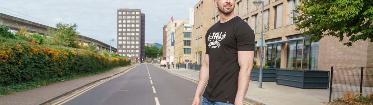 A tall athletic guy wearing a black XL tall graphic t-shirt.