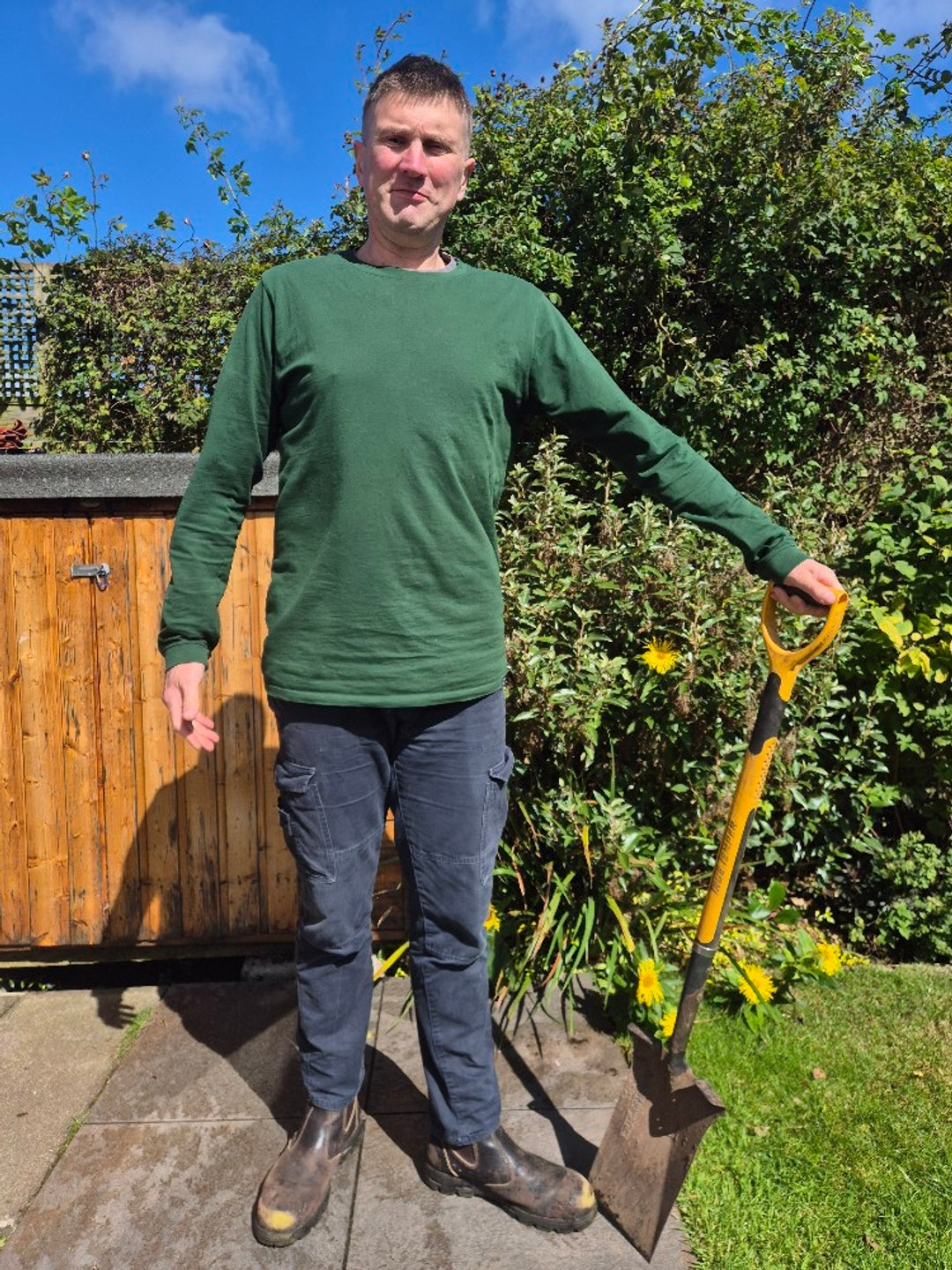 Chris Davis,  a tall slim guy, wearing our XL tall dark green long sleeve t-shirt.