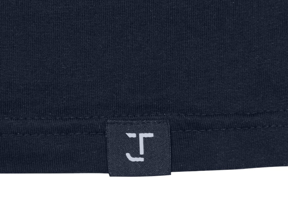 A close up of the Just Tall monogram logo on the bottom t-shirt hem.