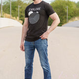 A head to toe shot of a tall skinny guy wearing a tall black graphic t-shirt.