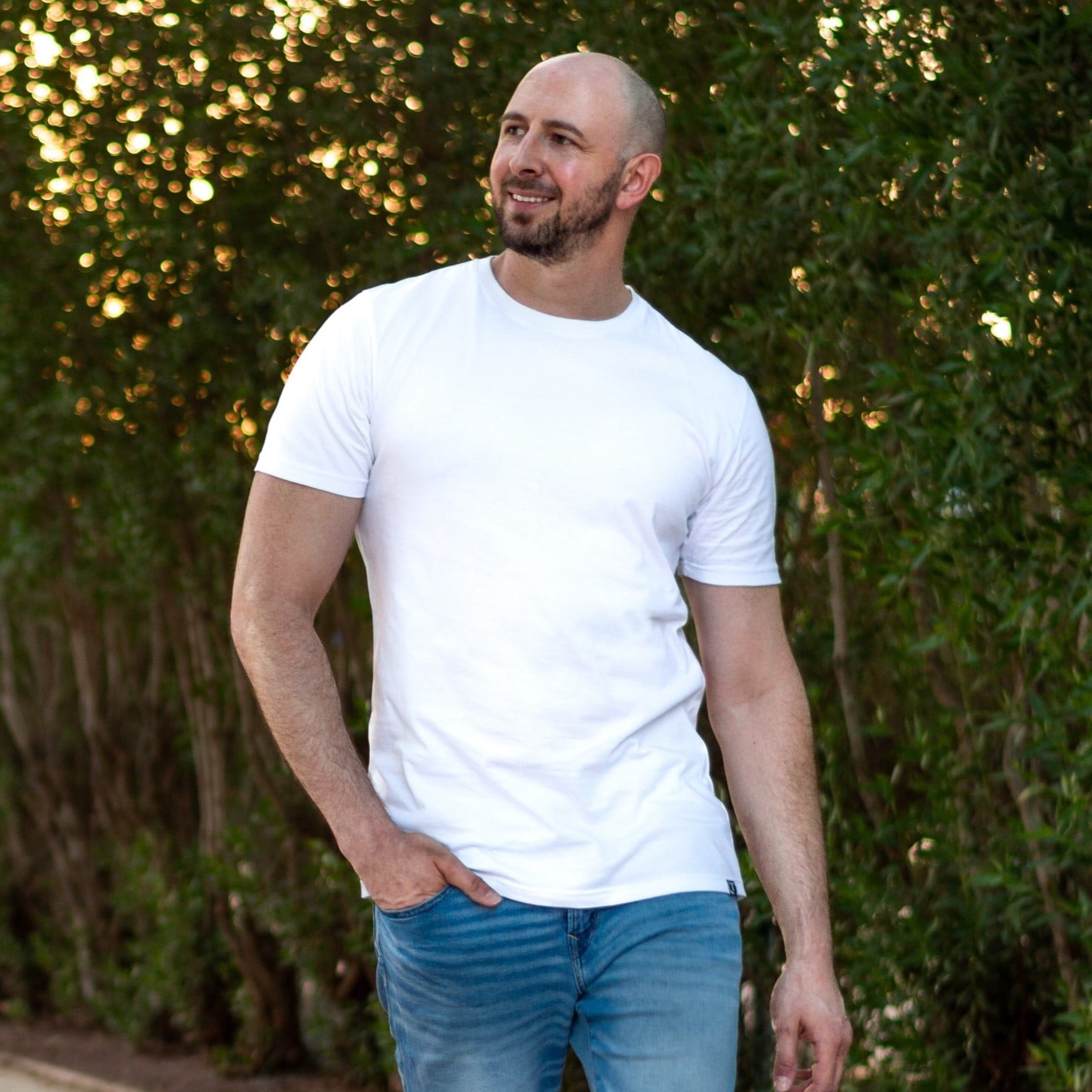 A tall skinny guy standing in a park and wearing an XL tall slim fitting t-shirts.