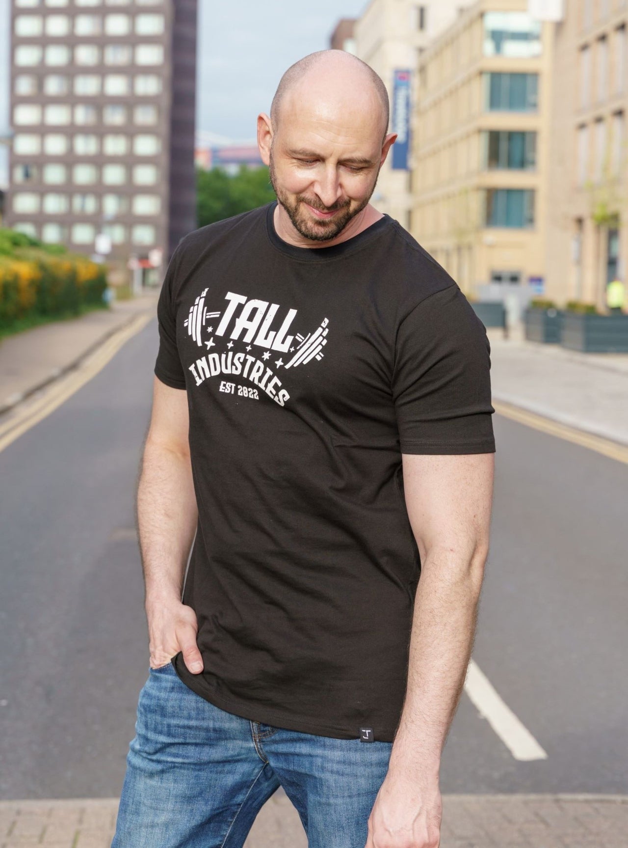 A tall skinny guy wearing a tall black slim t-shirt.