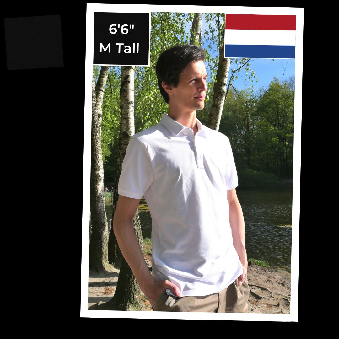 A picture of 6'6" Joshua standard next to a lake and wearing our medium tall white polo.