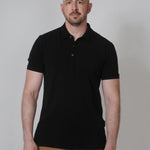 A tall slim guy in a studip and wearing a black XL tall polo shirt.