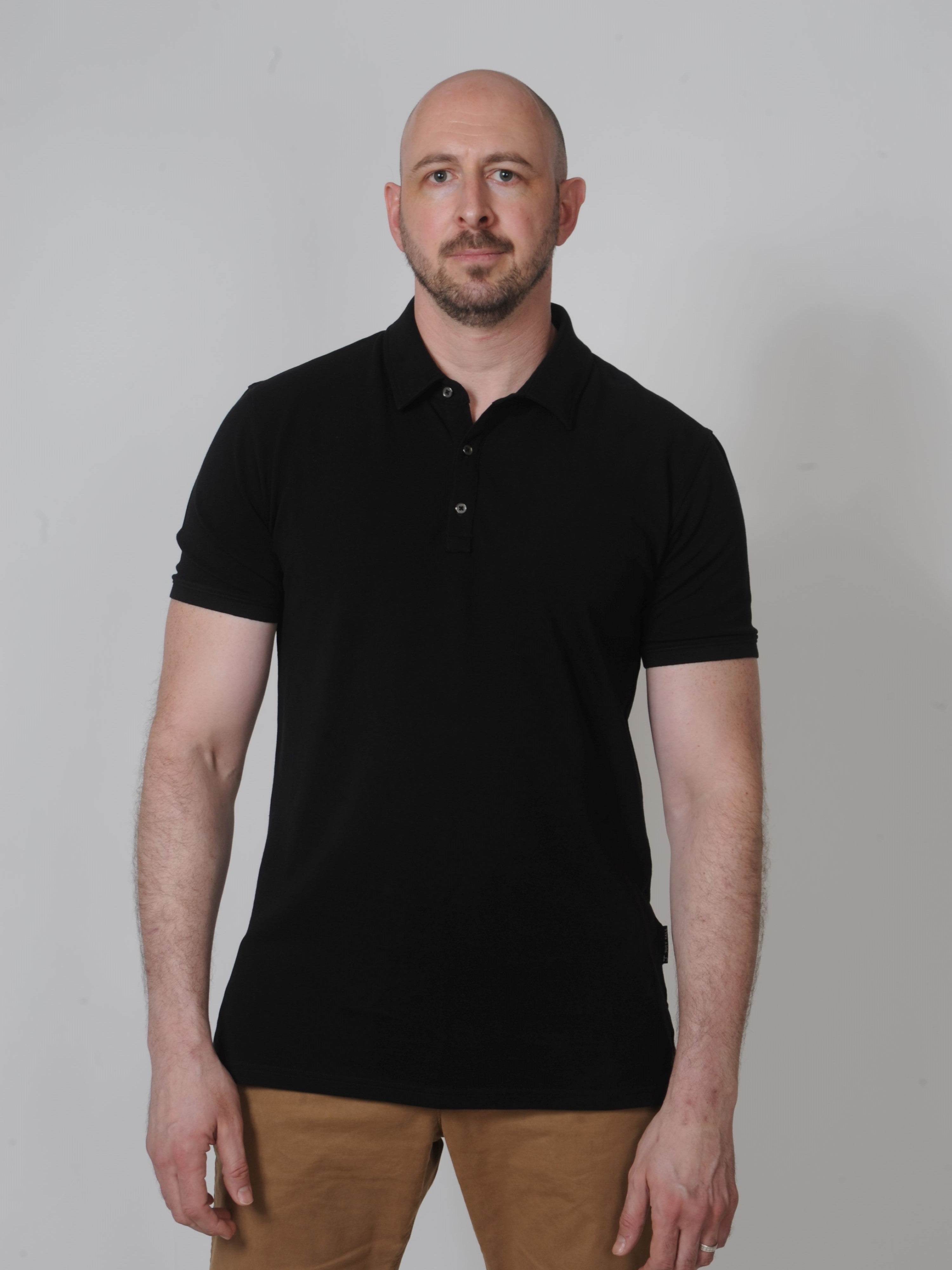 A tall slim guy in a studip and wearing a black XL tall polo shirt.